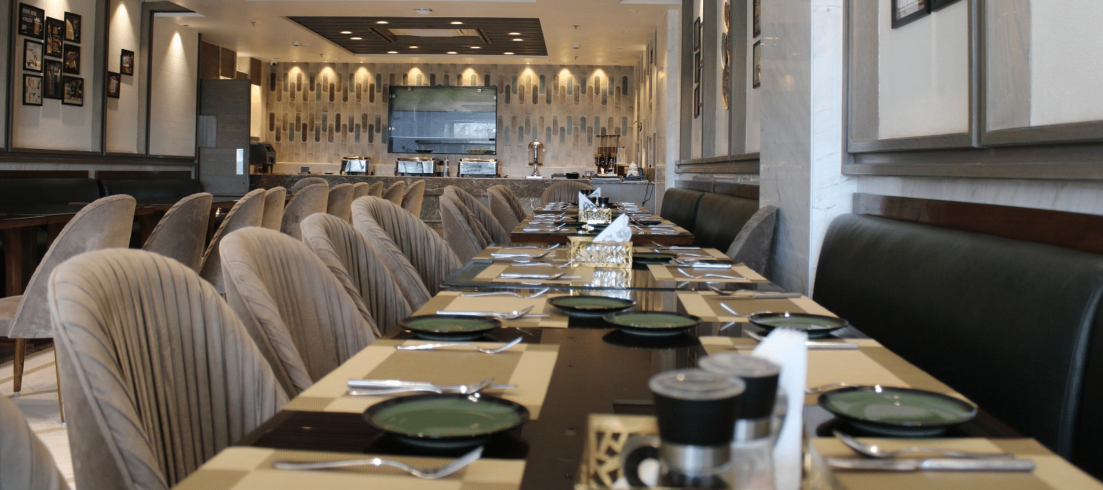 A well-arranged dining space featuring tables with chairs and neatly set cutlery at  BluSalzz Residence, Amritsar
